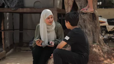Dr. Samar al-Hajj speaks with a young boy in a refugee camp.