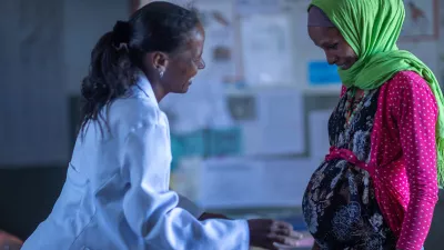 A pregnant woman speaks with a health worker at a clinic